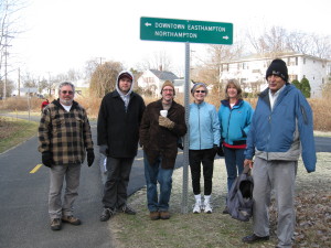 Manhan Rail Trail Committee members Peter Brooks, Mike Chevrette, John Losito, Carla Katz, Barbara LaBombard and Bill Burkart pose in front of the new sign at the fork in the trail near Ferry St. Easthampton.